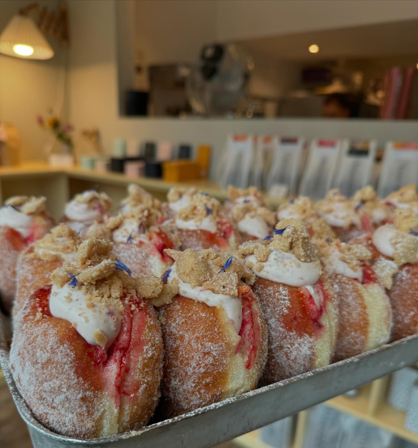 A tray of doughnuts filled with jam and cream.