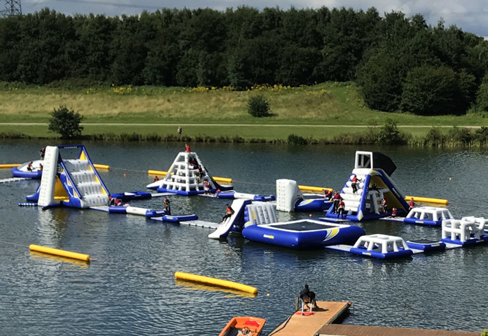 A variety of inflatable obstacles are floating on a lake. 