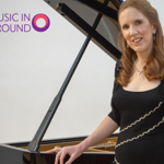 A woman in an evening gown leans against a grand piano.