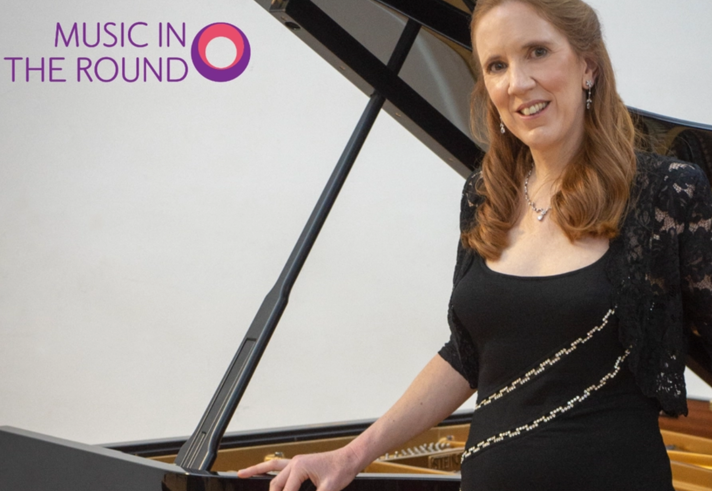 A woman in an evening gown leans against a grand piano.