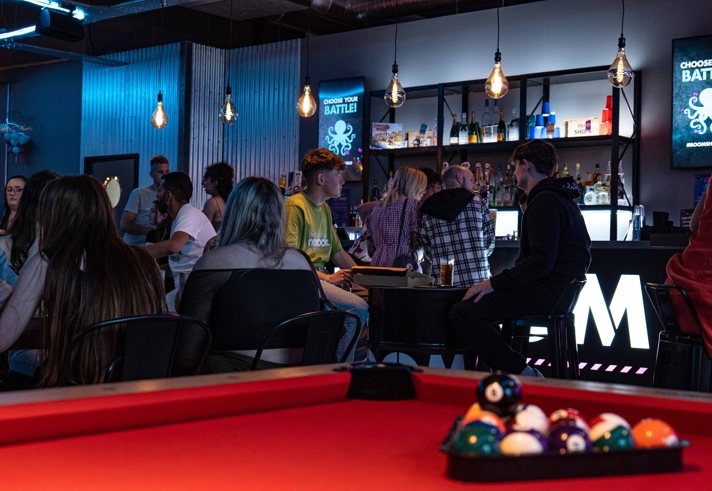 Pool table with the balls racked up at Boom Battle Bar.