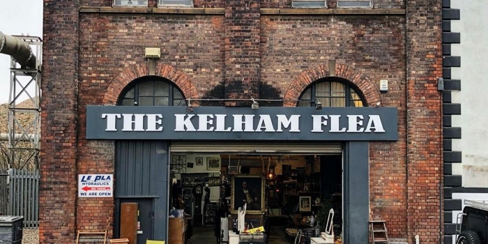 Exterior of an old red brick warehouse, over the open doors is a sign that reads 'The Kelham Flea'.