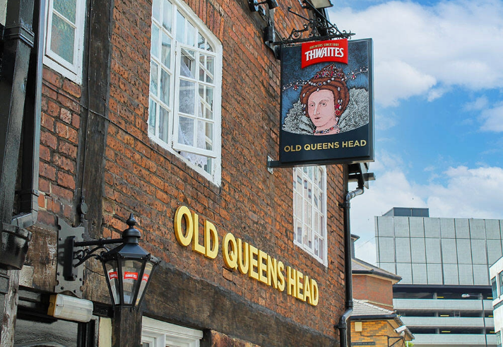 The exterior of The Old Queens Head with their pub sign.