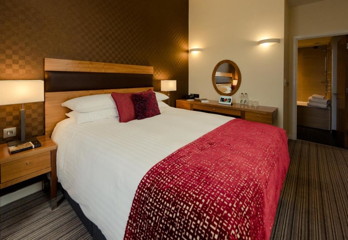 Bedroom at the Leopold Hotel with double bed and soft furnishings.