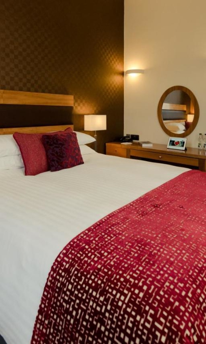 Bedroom at the Leopold Hotel with double bed and soft furnishings.