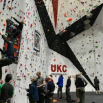 A big climbing wall at Awesome Walls Climbing Centre Sheffield. There are lots people climbing or waiting to climb.
