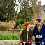 Two people cycling through a village in the Peak District National Park.