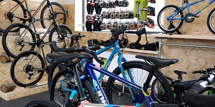 The interior of a shop filled with bikes and cycling equipment on display.