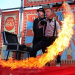 An illusionist creates a ring of fire on stage while an assistant watches on 