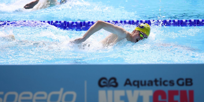 Swimmers racing in lanes in a pool.