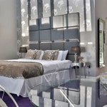 Opulent hotel bedroom at Aston Hall Hotel with king-size bed, cushions, and warm lighting creating a relaxing ambiance.