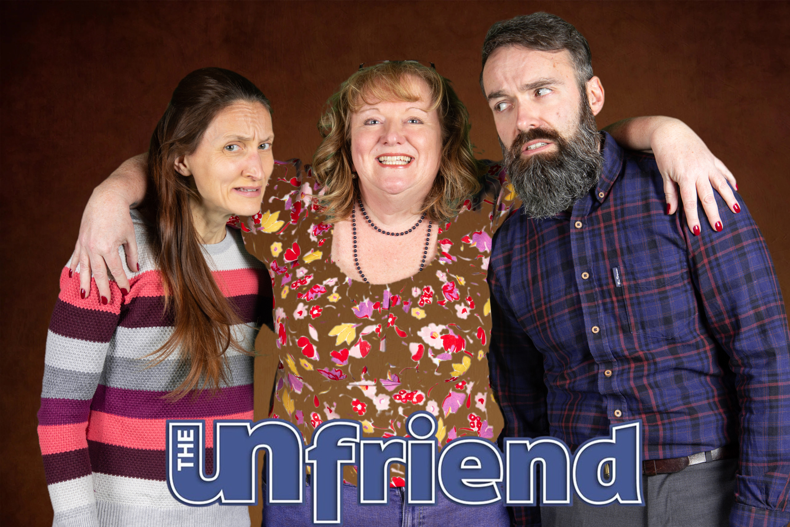 Three people are standing facing the onlooker. The person in the middle has their arms around the other two and is smiling broadly. The other two are looking distinctly uncomfortable. 