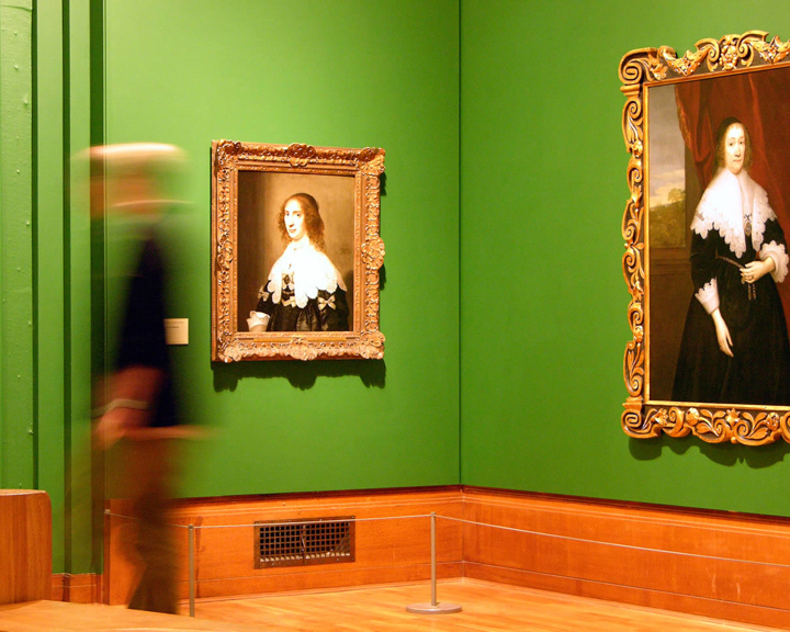 Inside Graves Gallery awoman walks past a painting.