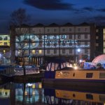 The canal basin and surrounding buildings lit up at night at Victoria Quays.