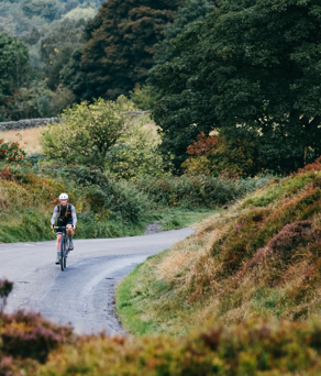 A cyclist on a road bike cycles through the country side.