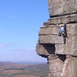 A person scaling a rock face.