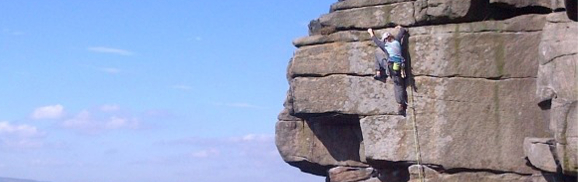 A person scaling a rock face.
