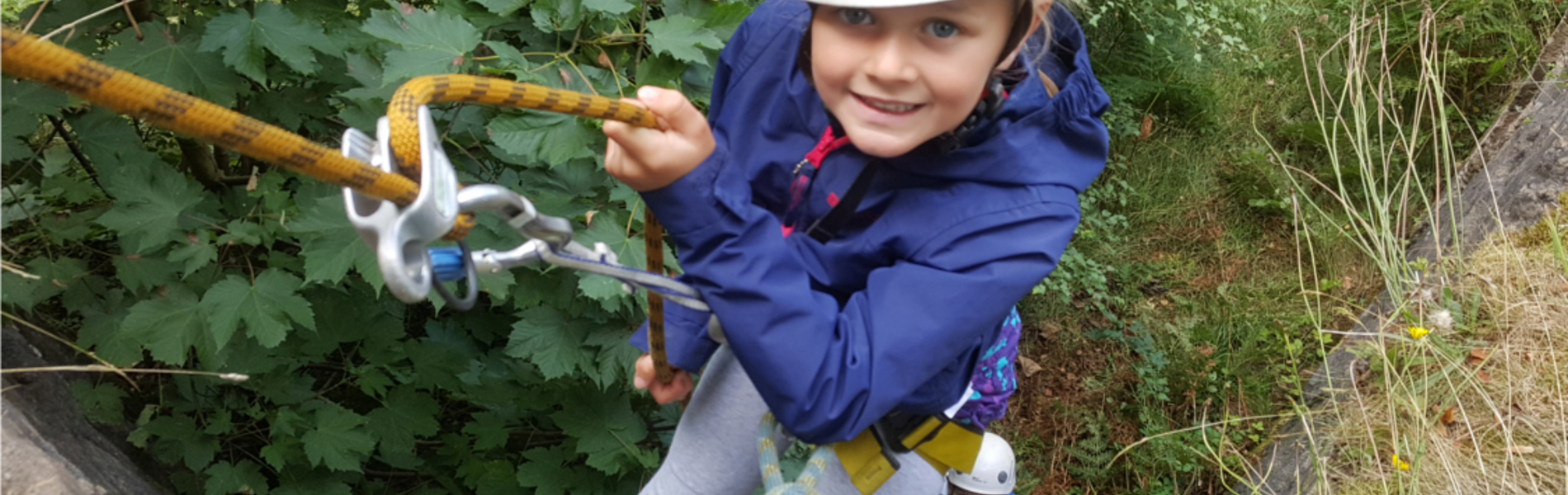 A child abseiling down a rock-face. 