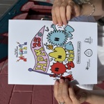 A person holding an A4 poster for the event.