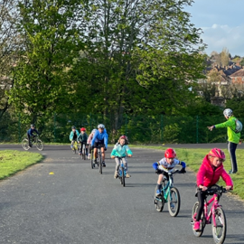 A group of children taking part in an outdoor cycling activity.