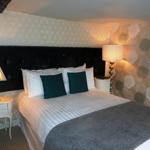 Spacious double bedroom with a large bed, ample floor space, bedside tables.