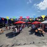 People enjoying an outdoor music festival in the sunshine.