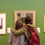 Two people looking at a painting inside Graves Gallery.