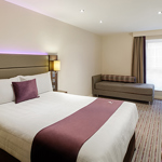 Hotel room with a double bed featuring soft furnishings and decorative cushions.