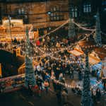 Looking Down On Log Cabins At Sheffield Christmas Market. Everywhere is lit up with Christmas lights and strings of fairy lights.