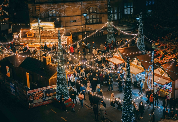 Looking Down On Log Cabins At Sheffield Christmas Market. Everywhere is lit up with Christmas lights and strings of fairy lights.