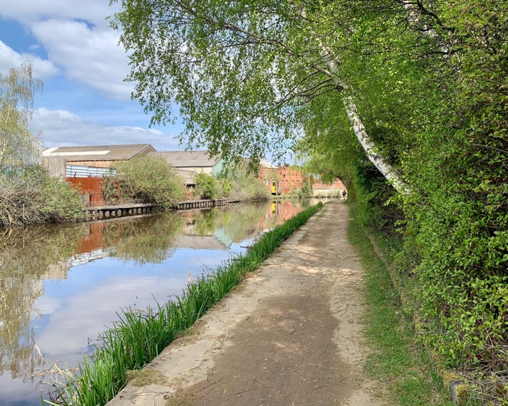 A tow path runs along the side of an inner city canal.