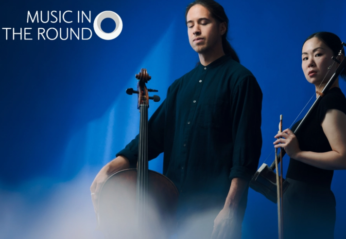 Two musicians stand in front of a rippling blue background holding their instruments.