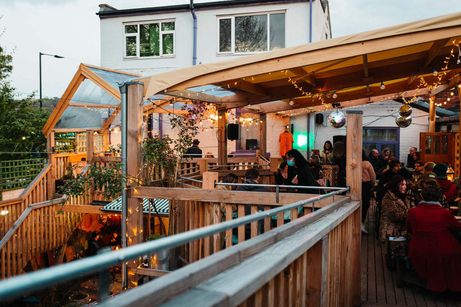 The covered balcony at Hagglers Corner, filled with people eating and drinking.