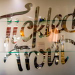 The Tickled Trout logo etched in a frosted glass window.