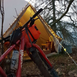 A bike and a tent in the countryside.