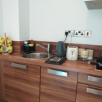 Compact kitchenette with a kettle and tea and coffee making facilities on the counter.