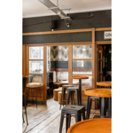 The interior at The Gin Bar with tall tables and bar stools.