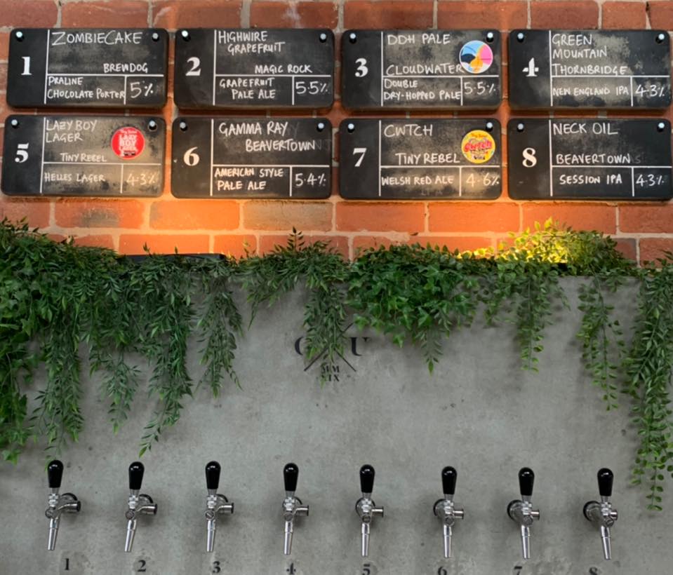 Beer pumps set into a wall behind the bar at Saw Grinders Union.