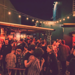 The beer garden at The Washington, filled with customers, at night.