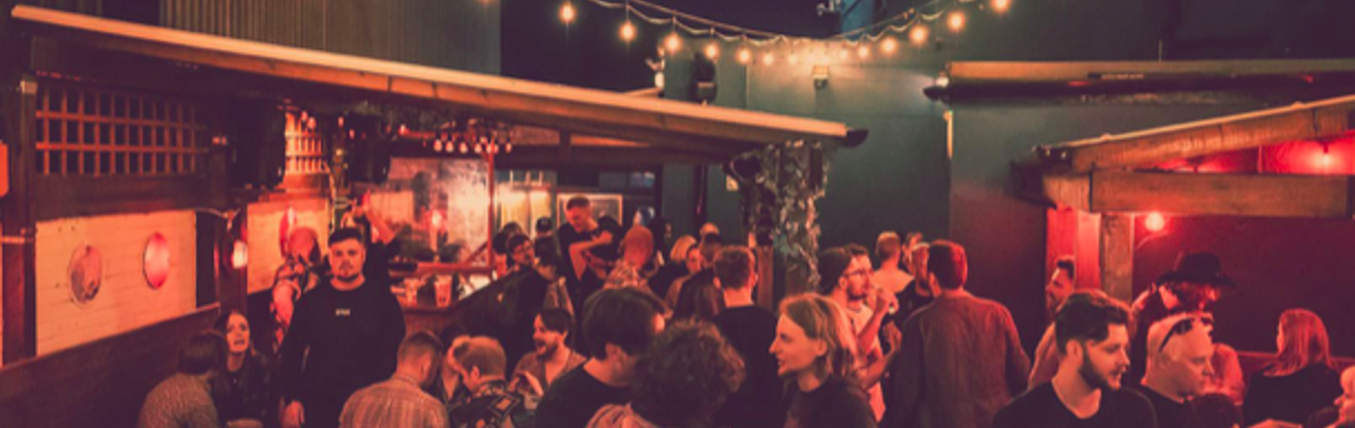 The beer garden at The Washington, filled with customers, at night.