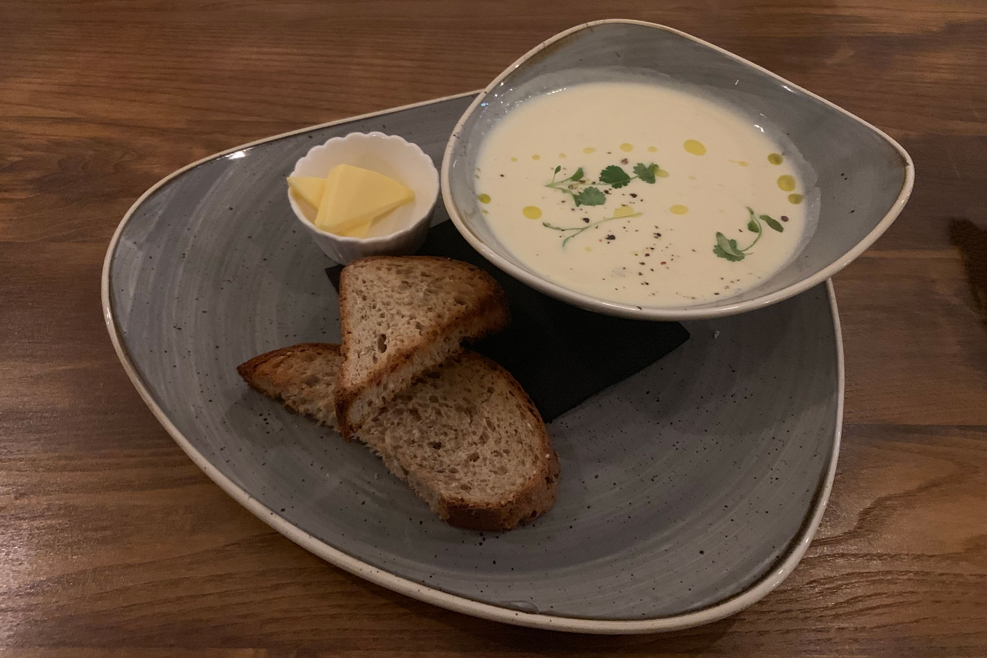 A bowl of soups with some crusty bread.
