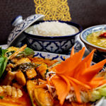 Three colourful dishes of food on a table at the All Siam Thai Restaurant.