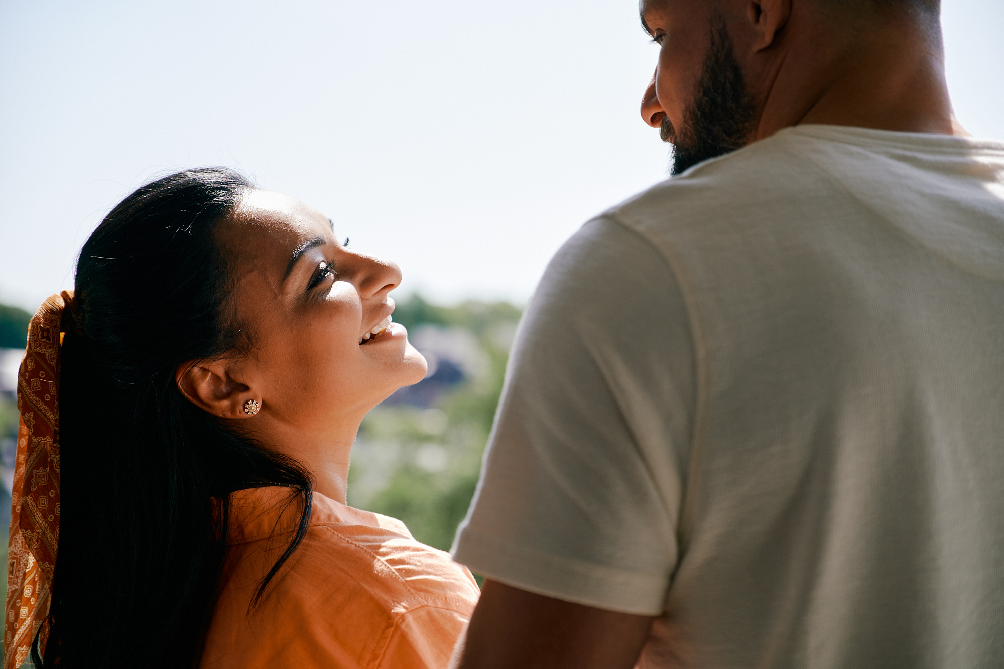A couple at an open window, looking into each others eyes happily.