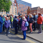 A tour guide talks to a group of people on a tour in Sheffield.