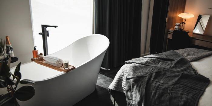 A bedroom with a free standing bath.