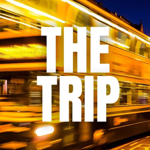 A motion blurred image of a double decker bus at might, with the words 'THE TRIP' overlaid on the centre of the image in bold white text.