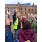 A tour guide talks to a group of people on a tour in Sheffield.