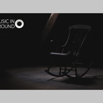 A rocking chair sits empty in a darkened room.