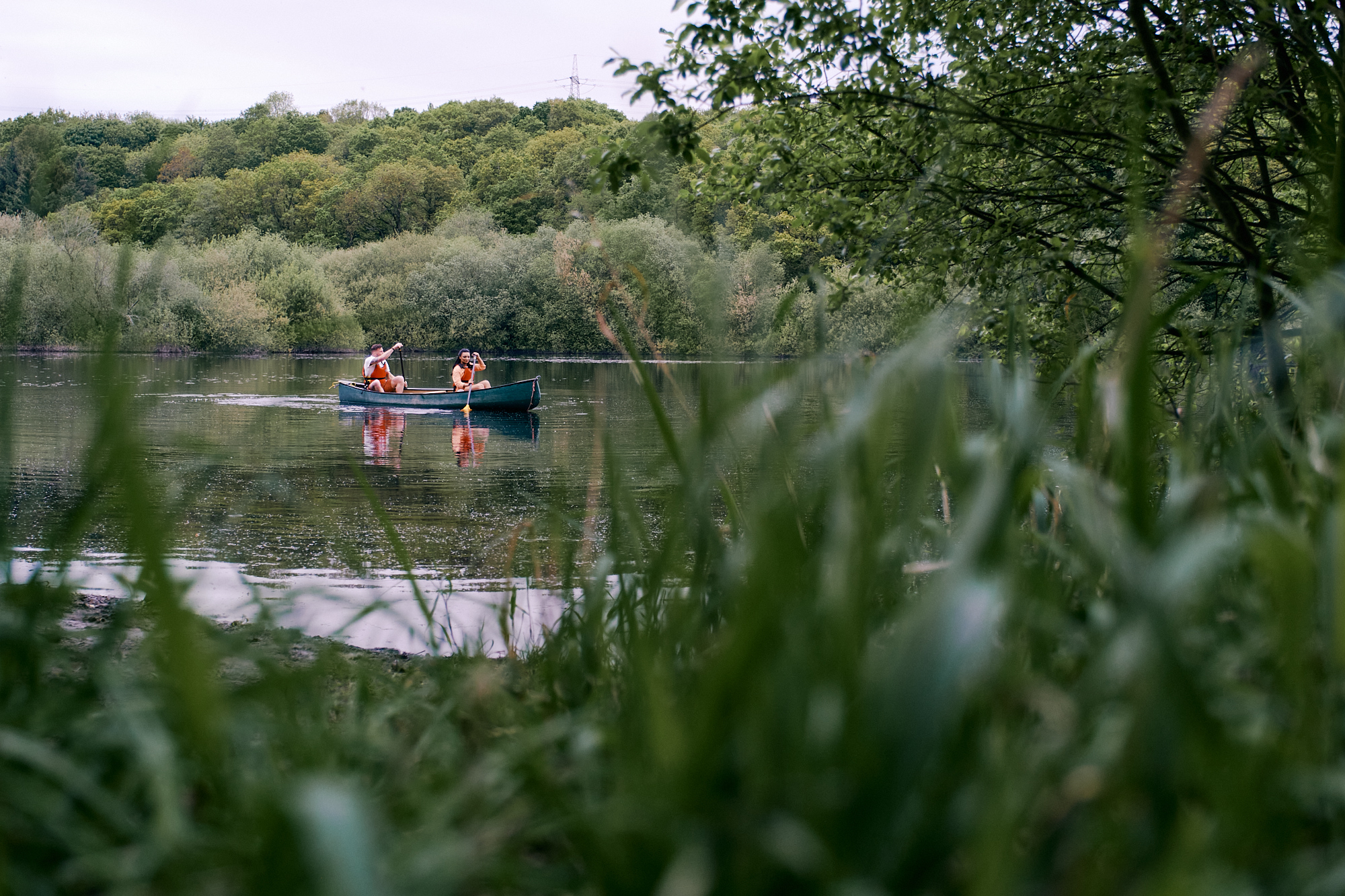 Two people in a kayak paddle across a stretch of water. 
