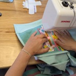 Close up of someone using a sewing machine.